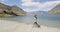 New Zealand travel happy tourist couple walking at beach of lake Hawea nature