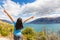 New Zealand travel happy tourist woman with arms up at Wanaka lake nature landscape outdoors. Wanderlust adventure young girl with
