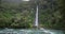 New Zealand waterfall nature landscape with Thunder Creek Falls and Haast River