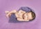 Newborn baby asleep on a purple blanket