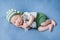 Newborn baby boy child sleeps in a green gnome costume and hugs a golden key