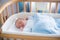 Newborn baby boy in hospital cot