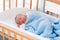 Newborn baby boy in hospital cot