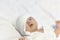 Newborn Baby Boy in Knit Hat Peacefully Lying on white