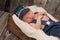 Newborn Baby Boy Wearing a Newsboy Cap and Suspenders