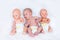 Newborn baby in diaper between two plastic dolls