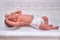A newborn baby in diapers on a white changing table with a ruler for measuring full-length
