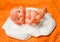 Newborn baby doll with Diapers - baby toy wear white diaper and playing on a orange knitted blanket in the nursery concept