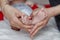 Newborn baby feet on mom and dad hands, shape like a lovely heart. happy family concept