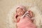 Newborn Baby Girl in Basket Wearing a Pink Bonnet