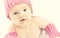Newborn baby girl in pink knitted hat and mittens.