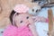 Newborn baby girl portrait in pink blanket lying in basket, cute child face