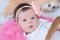 Newborn baby girl portrait in pink blanket lying in basket, cute face, new life