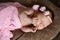 Newborn baby girl sleeping cute, covered with soft pink scarf, neatly folded under a pen with a small head with a pink bow, set