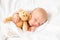 Newborn baby girl sleeping with teddy bear