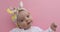 Newborn baby girl smiling pink background