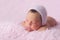Newborn Baby Girl Wearing a Pink Knitted Bonnet