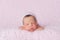 Newborn Baby Girl Wearing a Pink Knitted Bonnet