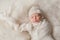 Newborn Baby Girl Wearing a White Knitted Bonnet