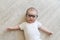 Newborn baby in glasses. A little boy in white clothes. Beautiful portrait of a toddler. Big-eyed baby. Distance learning. Remote