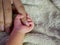 Newborn baby grasping her mothers finger. Concept of baby care, feeling safe, parent love. Selective soft focus