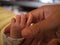 A newborn baby holding his father hand