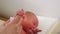 Newborn baby holds patential finger. Closeup. Parenthood. Motherhood. Happy family Mother and her infant together. Tiny