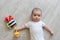 Newborn baby with ladybird. A little boy in white clothes with ladybug. Beautiful portrait of a toddler. Big-eyed baby.