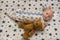 A newborn baby lies in the crib with a teddy bear, top view