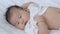 Newborn baby lying on the bed and looking at camera. Healthy children concept.