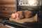 Newborn baby is lying on the oven tray with a muffins