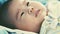 Newborn baby lying and relaxing on the bed. Healthy children concept. Cinematic style colors.