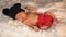 Newborn baby in mouse costume sleeping on fur bed