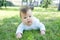 Newborn baby portrait learning crawling on grass 3 or 4 month. Baby outdoors