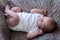 Newborn baby sleeping on his back top view full length