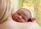 Newborn baby sleeping on mother\'s shoulder