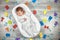 Newborn baby sleeps in a special orthopedic mattress Baby cocoon, on a wooden floor multicolored letters around. Calm