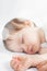 Newborn baby sweet sleeping on a white bed