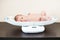 Newborn baby on weighing scale