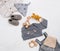 Newborn babys clothing, wooden beanbag and teether on marble background