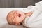 Newborn on the bed. Crying, screaming baby close up and copy space. Baby smile and colic in newborns. Seborrheic dermatitis in new