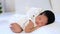 a newborn black African-American baby is sleeping sweetly on his tummy with a soft toy cat, a small dark-skinned baby is