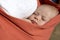 Newborn boy sleeping in baby sling carrier