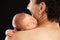 Newborn boy sleeping on his dad\'s shoulder