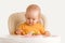 A newborn child aged one year tries boiled vegetables for the first time. A baby carefully takes a boiled carrot while sitting on