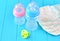 Newborn child stuff on a wooden background. Stack of baby disposable diapers, pacifier and feeding bottles close-up.