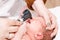 Newborn ENT exam - doctor checking nose with otoscope in pediatric clinic