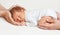 Newborn in Family Hands. Baby Sleeping in Mother and Father Palms over White Blanket. Parents holding dreaming Infant. Cute Child