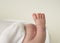 Newborn foot on beige background