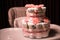 Newborn gift concept. Cake of diapers. Wrapped diapers as cake with flowers. Cake of wrapped clean diaper on table with baby doll